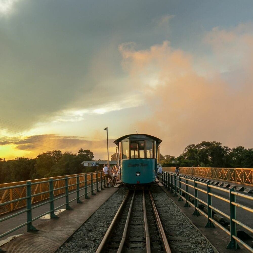 Bamba Tram crossing the Victoria Falls Bridge at sunset on a heritage tour