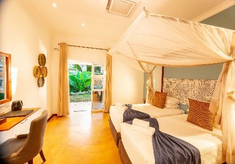 Guest room with a four-poster bed at Bayete Guest Lodge