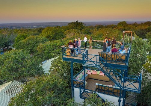 Guests on the lookout tower at Shongwe Lookout, Victoria Falls, at sunset