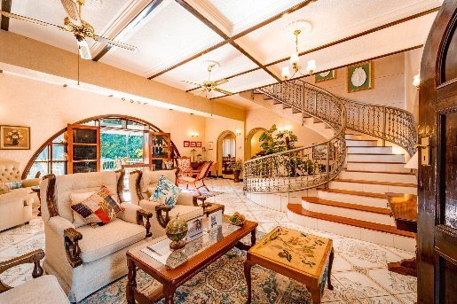 Lounge with a sweeping staircase at The Victorian Manor