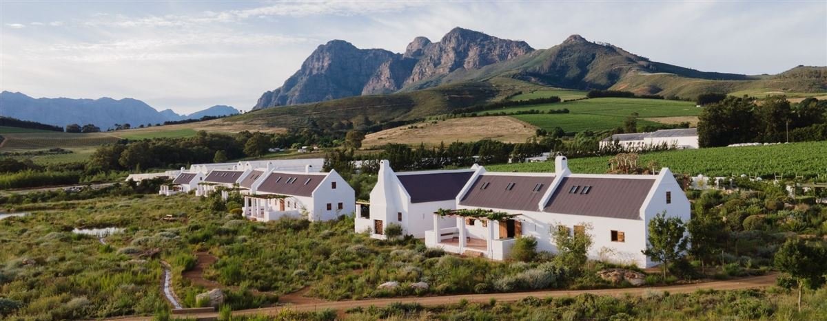 White Cape Dutch farm buildings beneath mountains in the Winelands