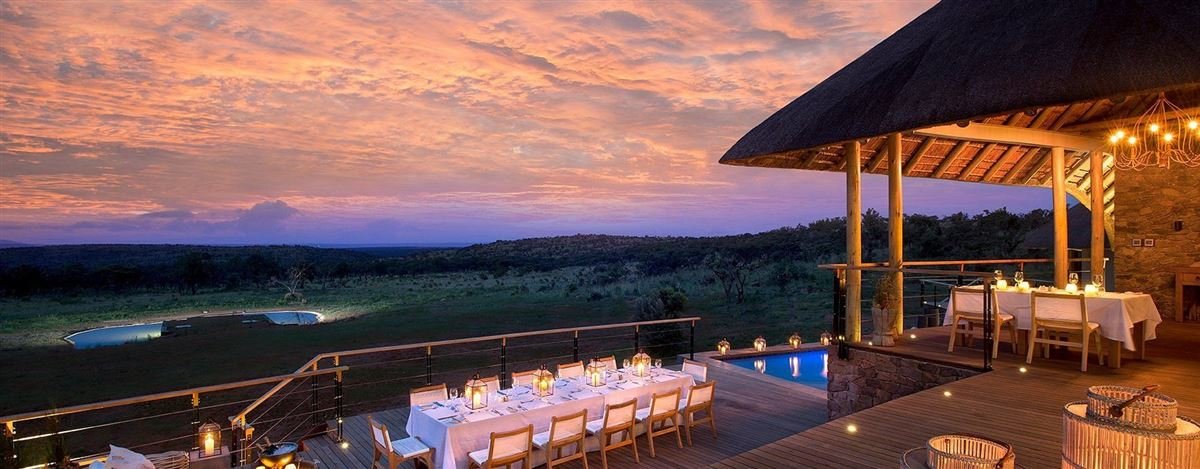 Safari lodge deck set for dinner at sunset