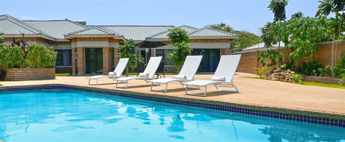 Swimming pool and sun loungers in front of the rooms at Dade House