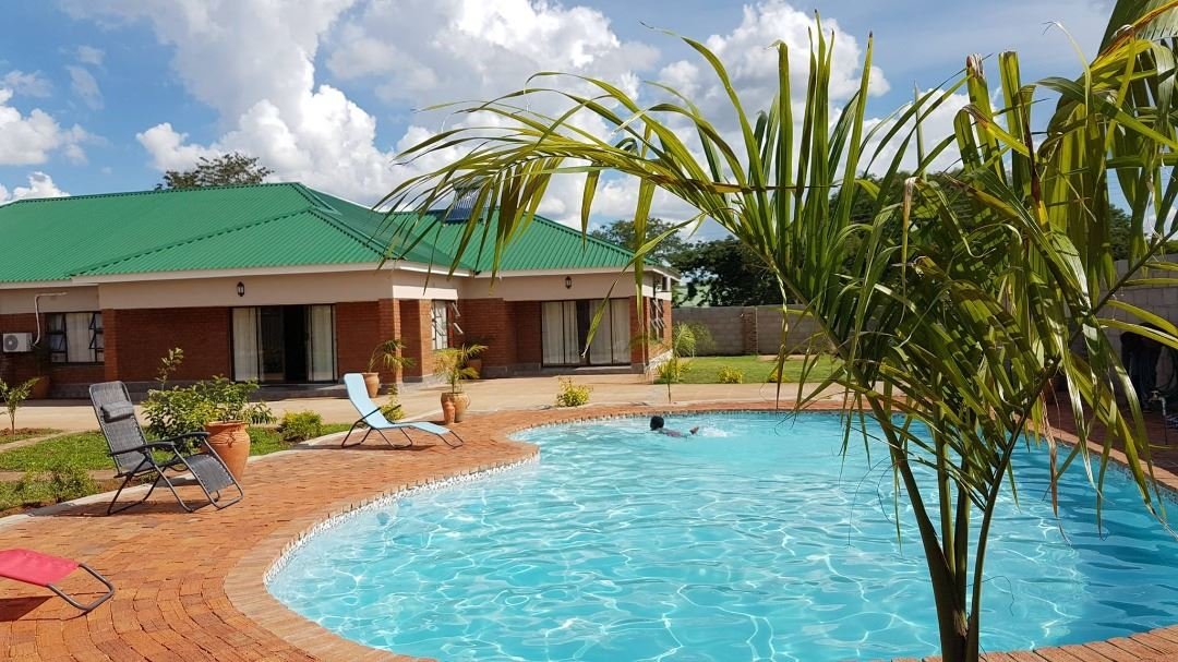 Curved swimming pool and garden bungalows at Dzimbahwe House