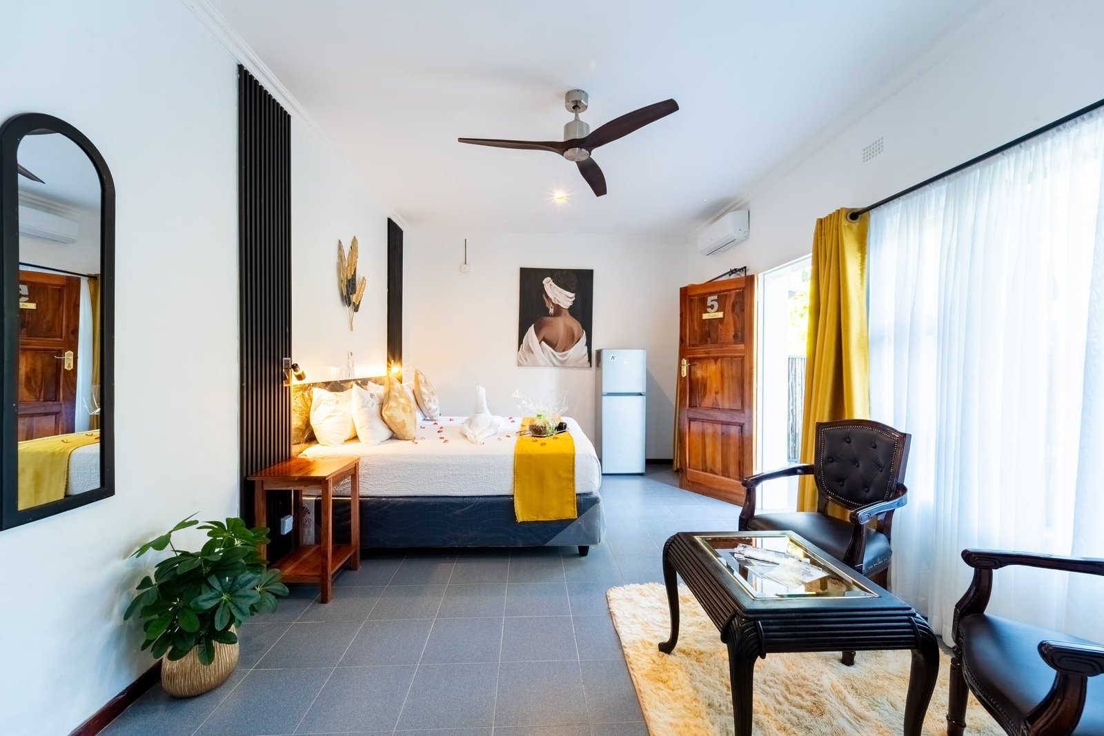 Executive room with an armchair and ceiling fan at Murugare, Victoria Falls