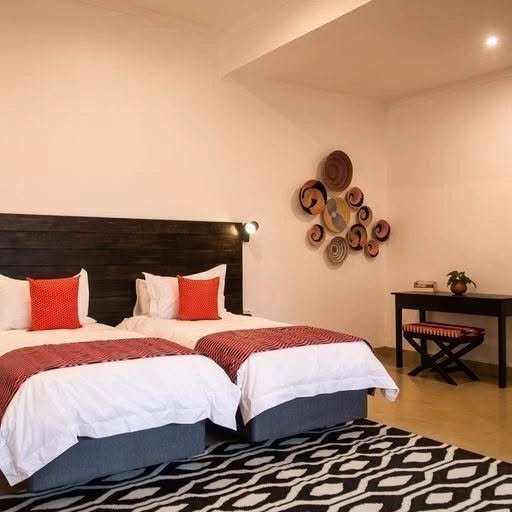 Twin beds with patterned rug at Tabokana House