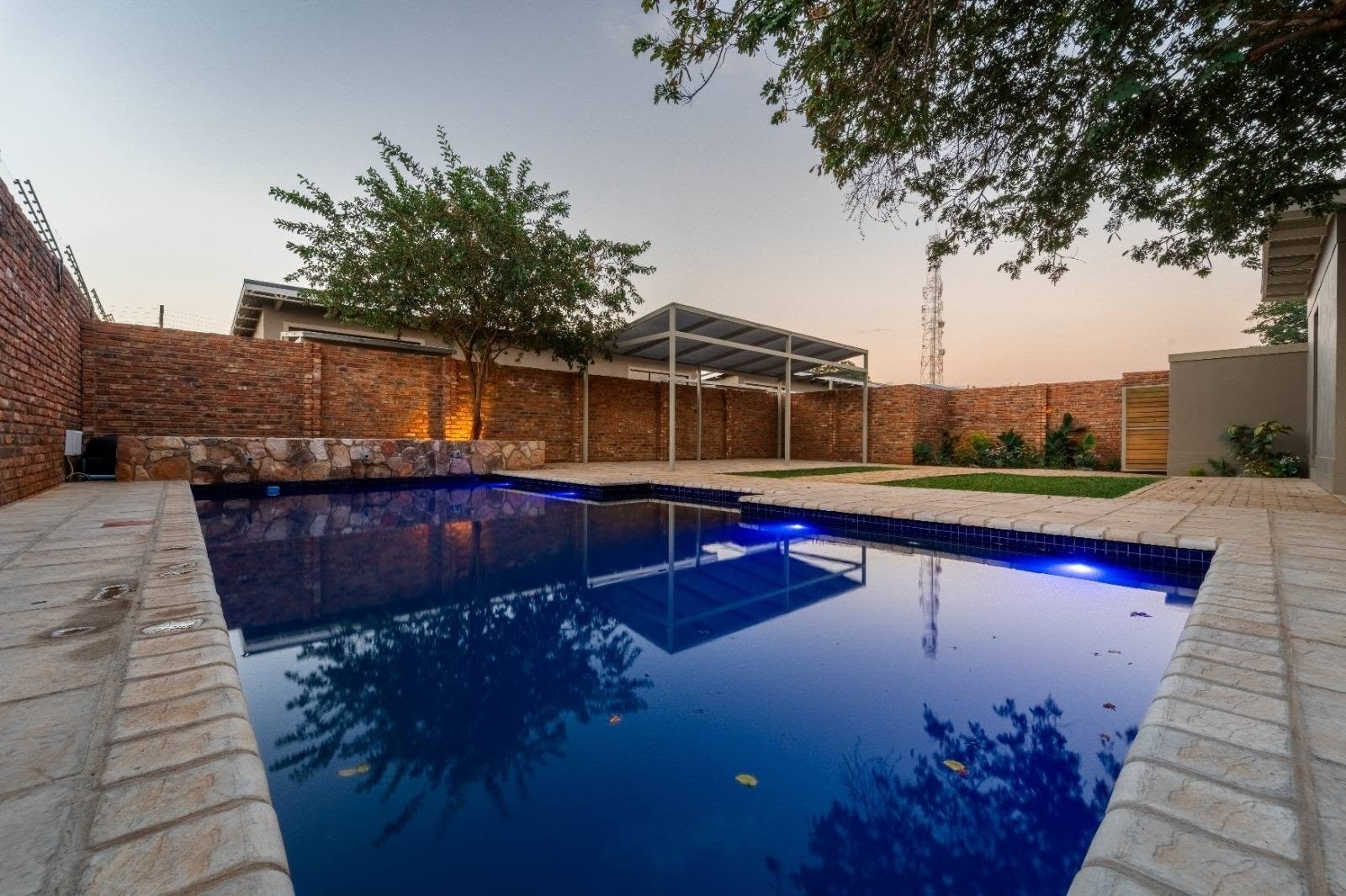 Swimming pool lit at dusk at The Pods Victoria Falls