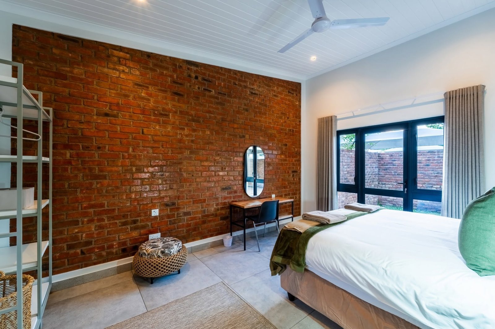 Bedroom with an exposed brick wall at The Pods Victoria Falls
