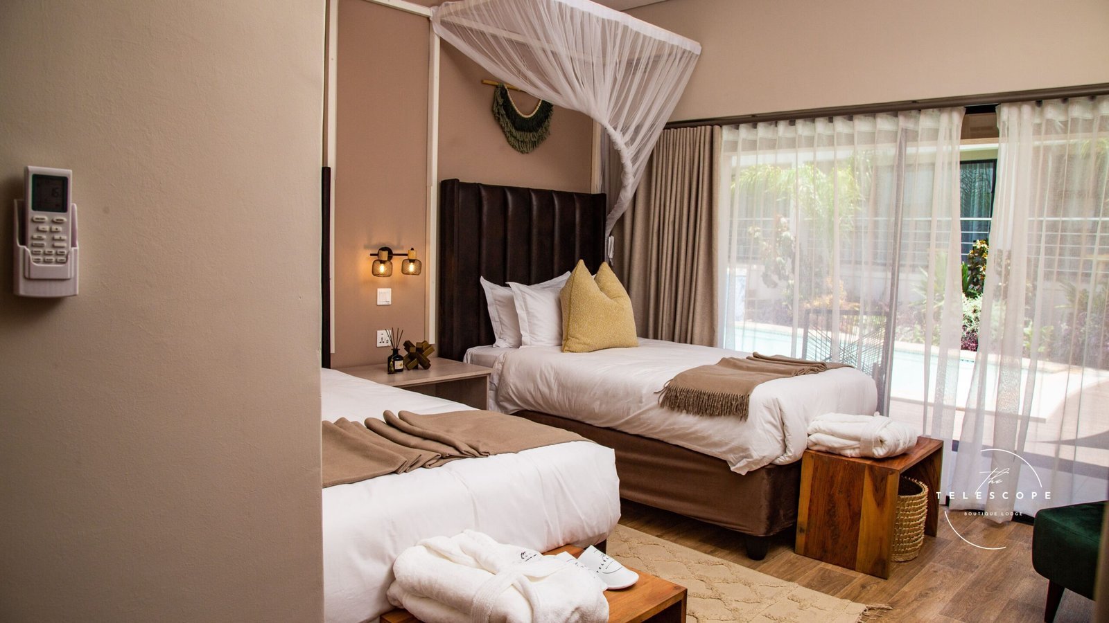 Bedroom with mosquito net and garden doors at The Telescope Boutique Lodge, Victoria Falls