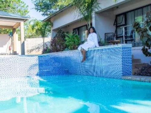 Guest by the swimming pool at The Telescope Boutique Lodge