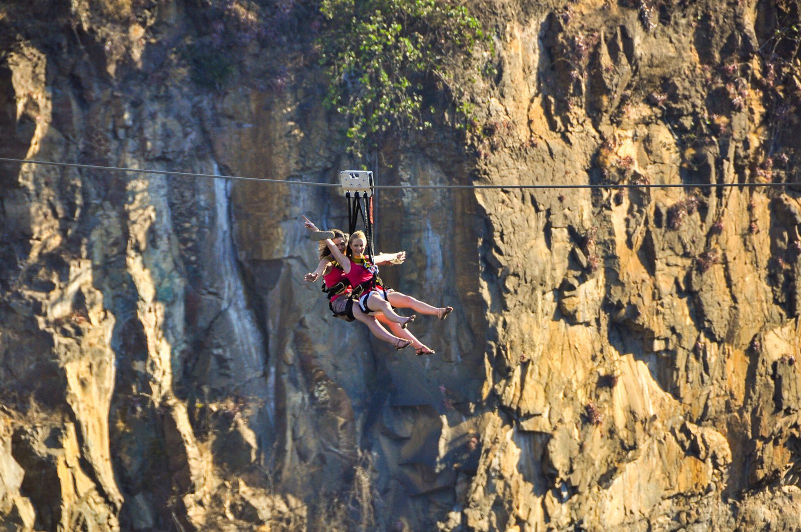 Rider on the bridge slide against the cliffs of the Batoka Gorge