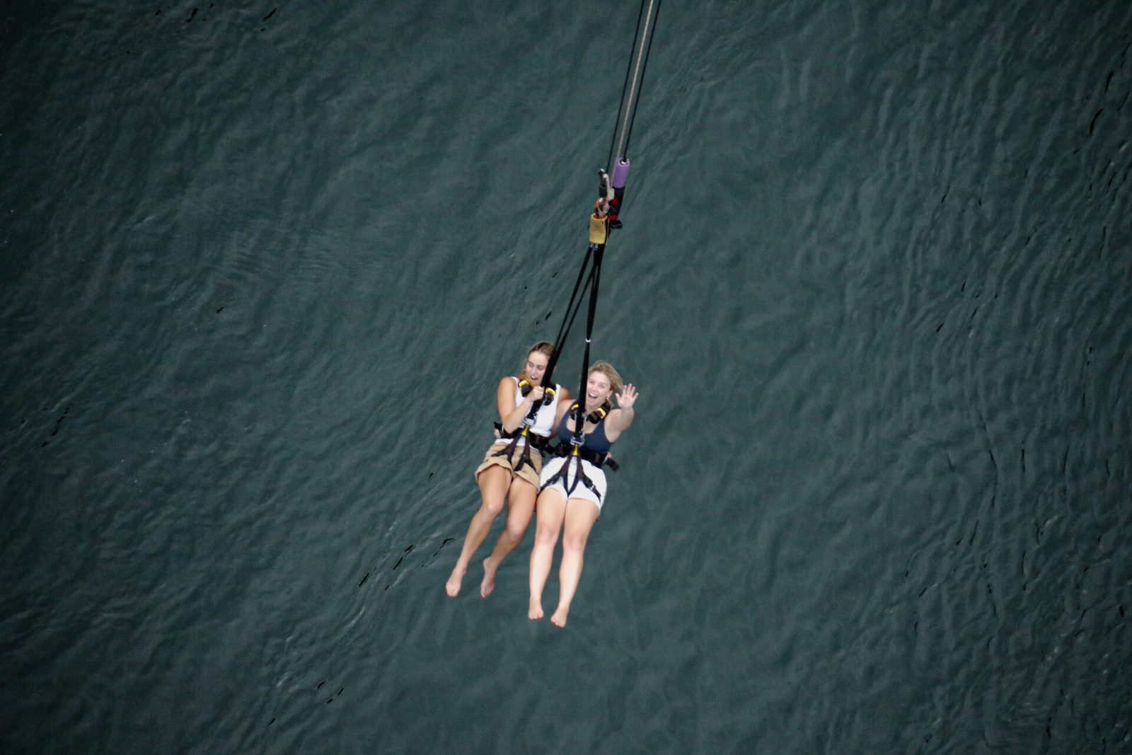 Two people swinging together high above the Zambezi on the bridge swing