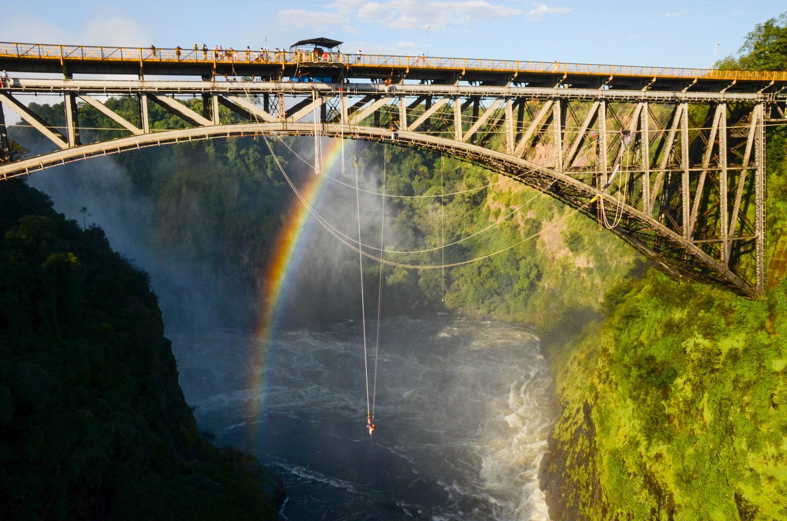 The Victoria Falls Bridge and a gorge rainbow seen from the bungee platform