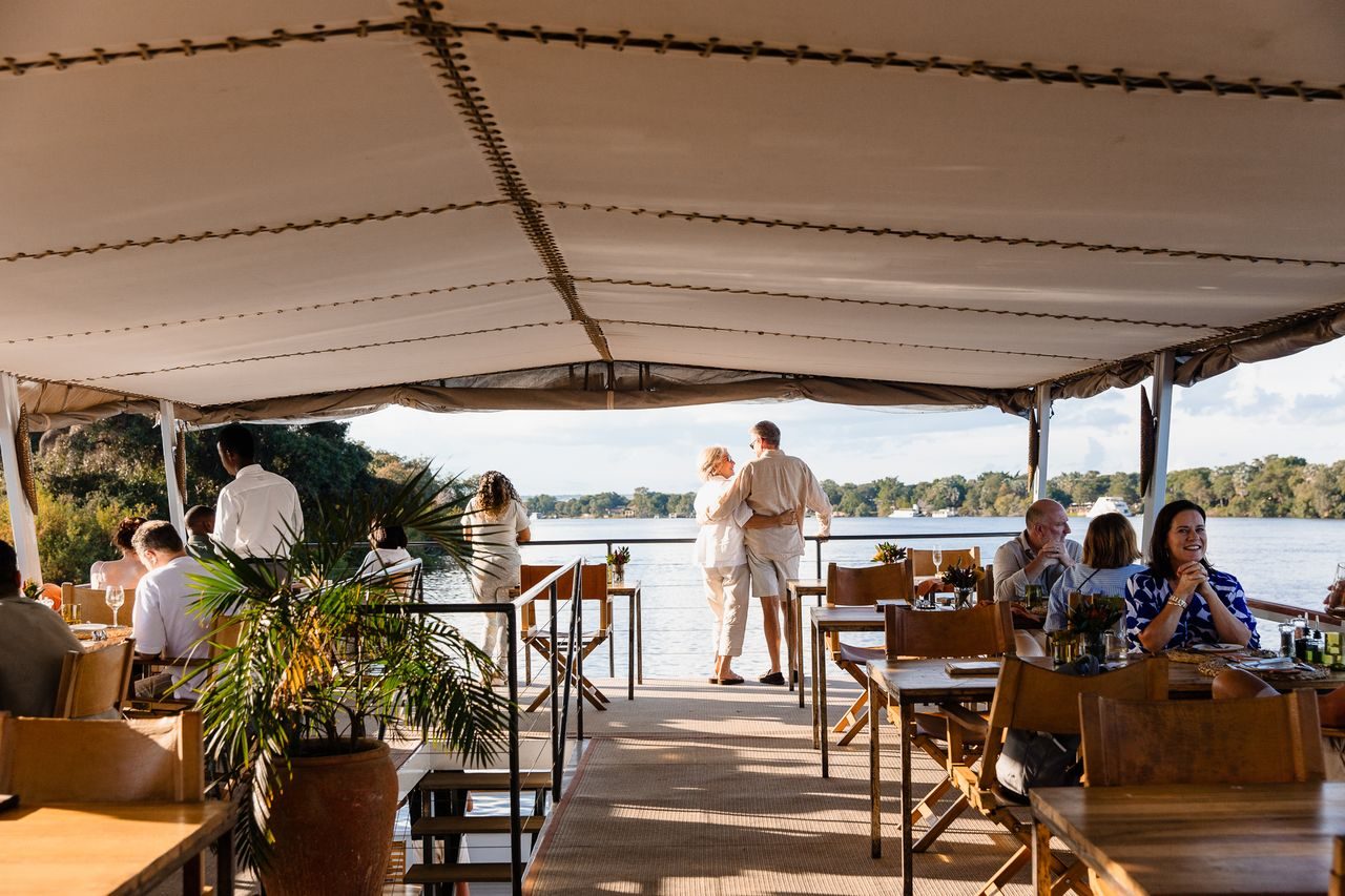 Open dining deck with tables set for the Zambezi dinner cruise