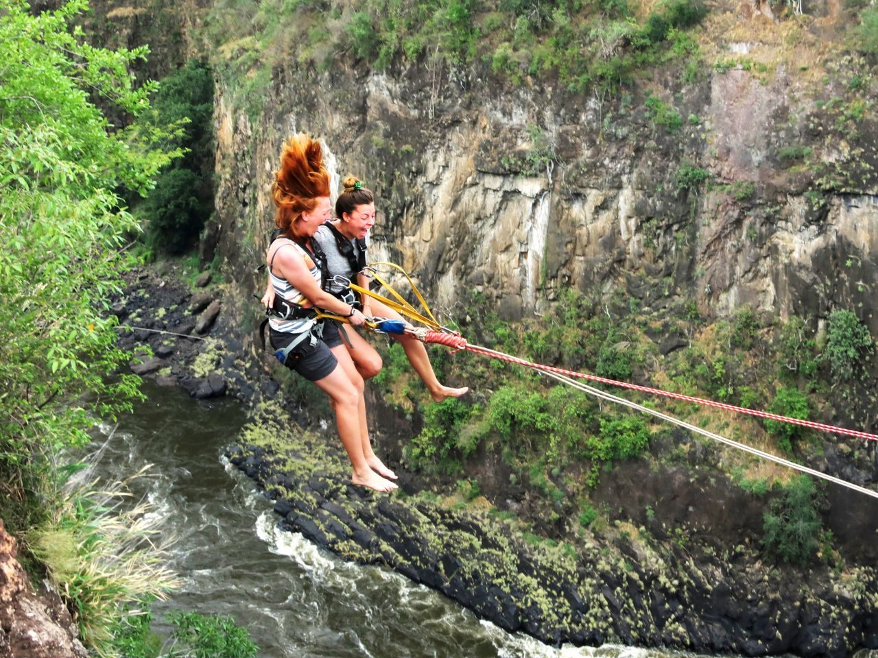 A woman swinging out across the Batoka Gorge on the gorge swing