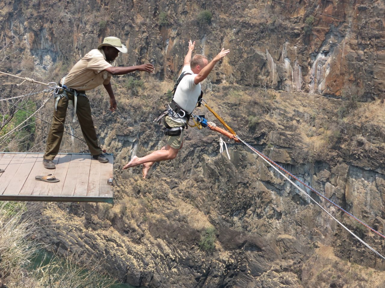 Two people leaping together from the gorge swing platform