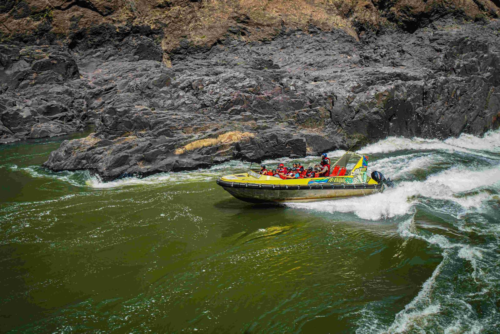 Guests holding on as the jet boat powers through white water