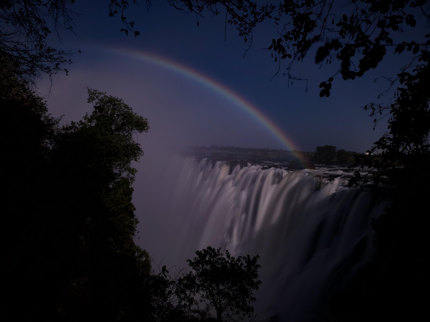 A moonbow arching over Victoria Falls under the full moon