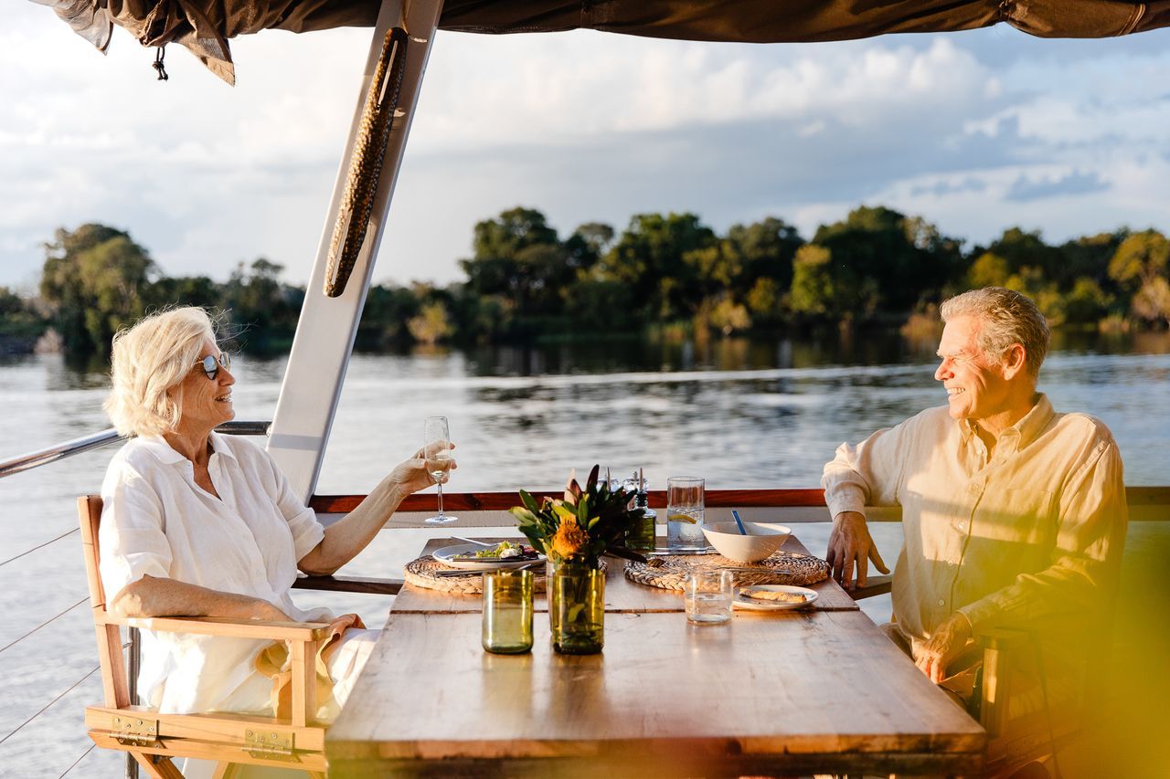 Couple having dinner on a sunset cruise boat on the Zambezi River