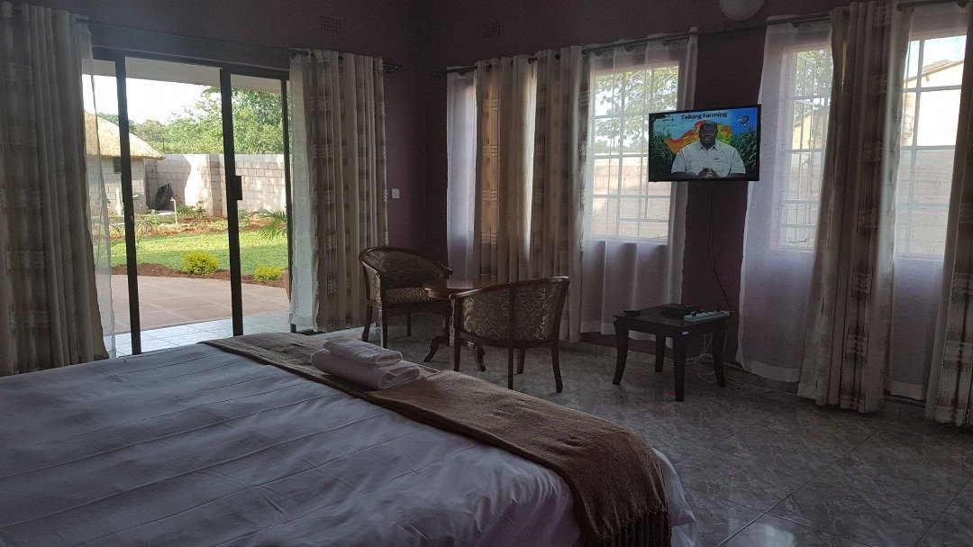 Bedroom with doors onto the garden at Dzimbahwe House