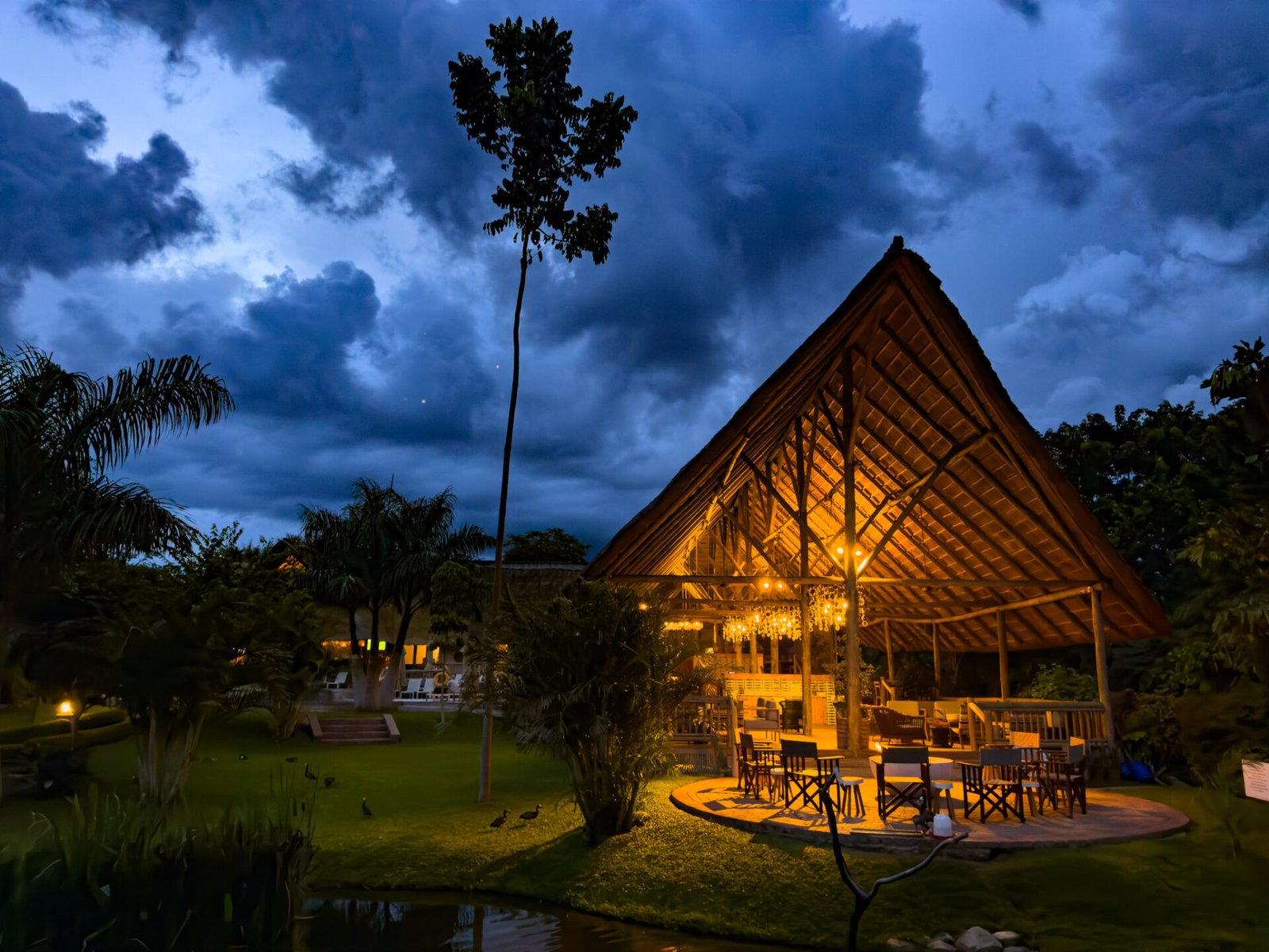 The thatched restaurant lit at night at Explorers Village