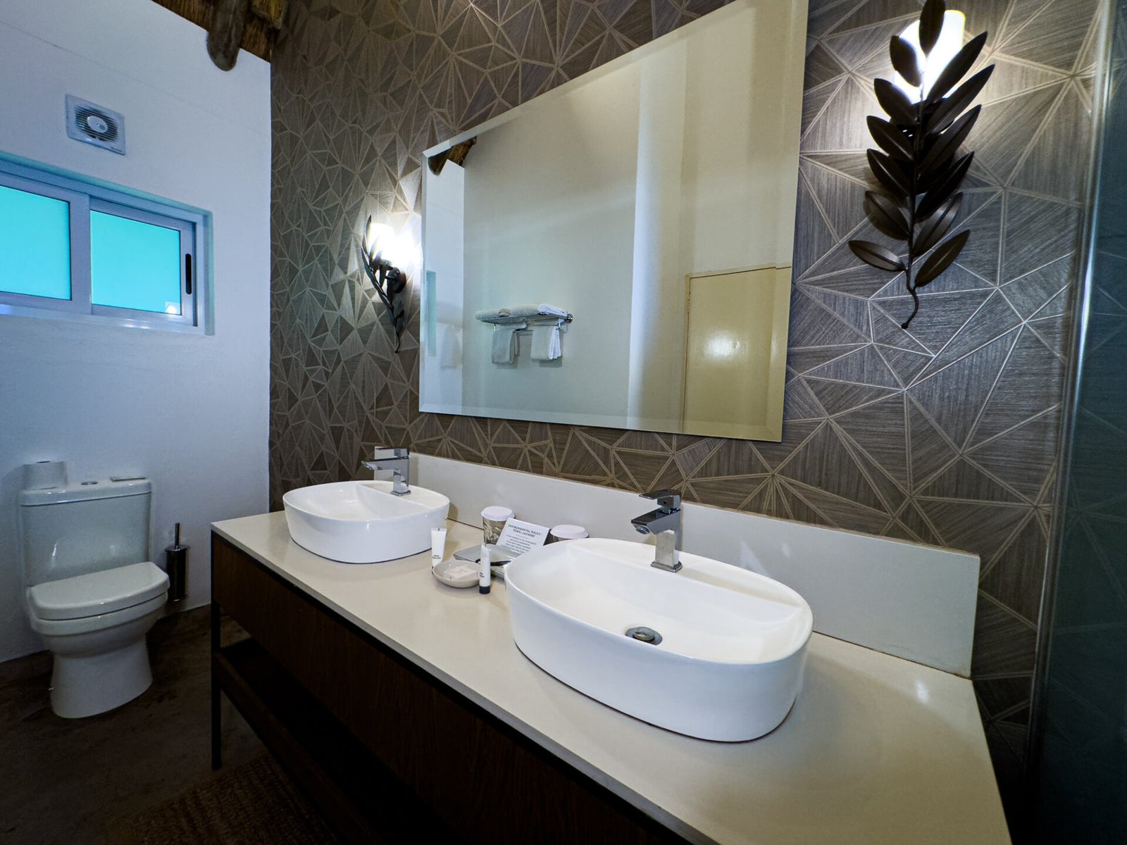 Bathroom with twin basins in a deluxe room at Explorers Village