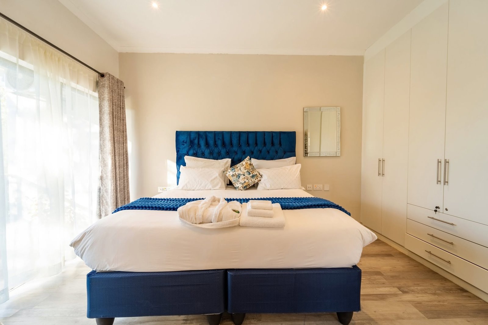 Bedroom with a blue headboard and built-in wardrobe at 533 Reynard Apartments