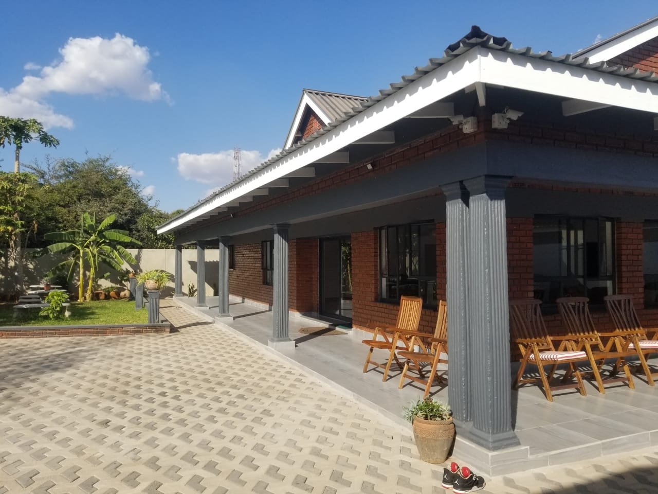 Covered veranda with a long table at Rupiya House