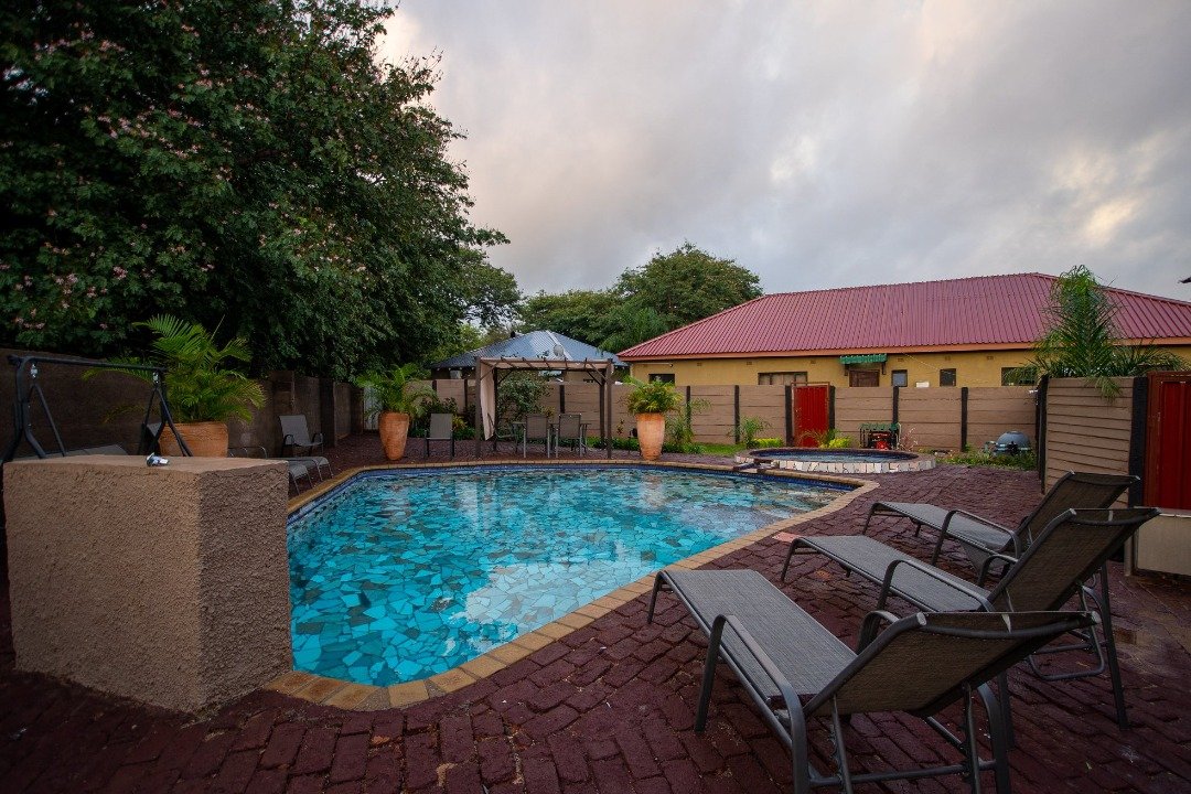 Swimming pool with loungers at Sweet Home, Victoria Falls