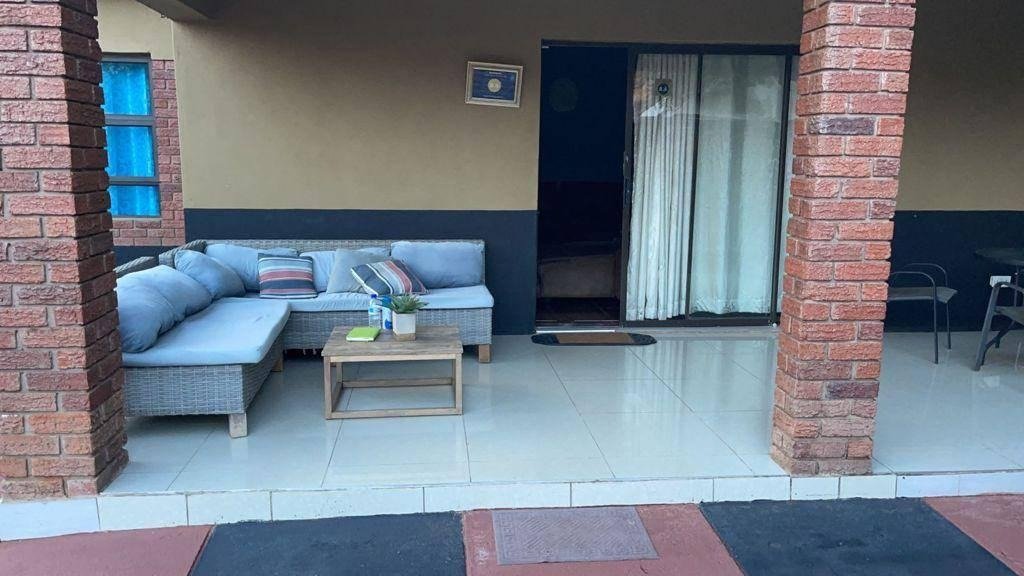 Covered patio lounge with blue sofas at Sweet Home