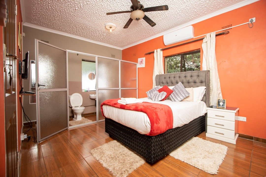 Bedroom with an orange feature wall at Sweet Home