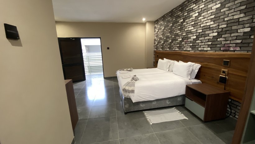 Room with a stone feature wall and TV at The Outlook Lodge