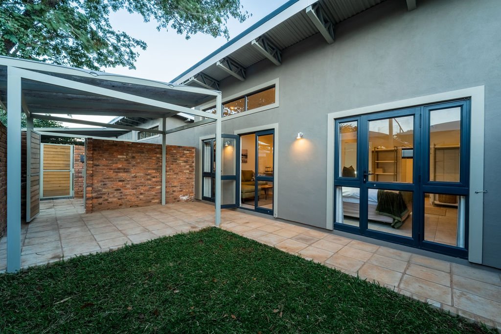 Courtyard with lawn and covered walkway between the villas at The Pods