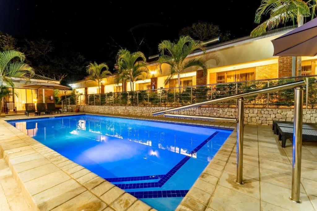 Swimming pool lit at night at The Shrub Lodge, Victoria Falls