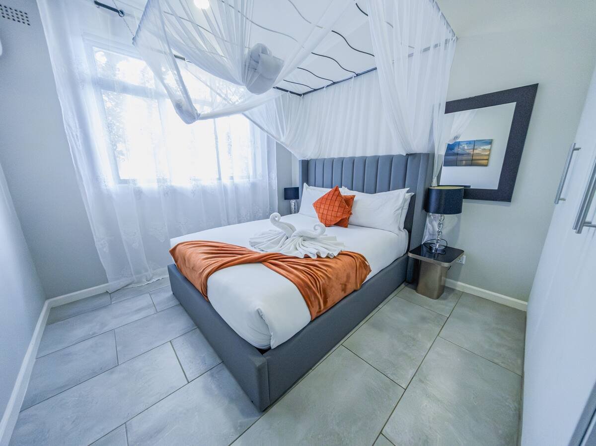 Bedroom with a mosquito net at Victoria Falls Estate